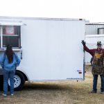 Man next to trailer waving for camera