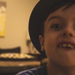 Closeup of smiling boy with hat