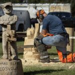 Man carving wood with chainsaw